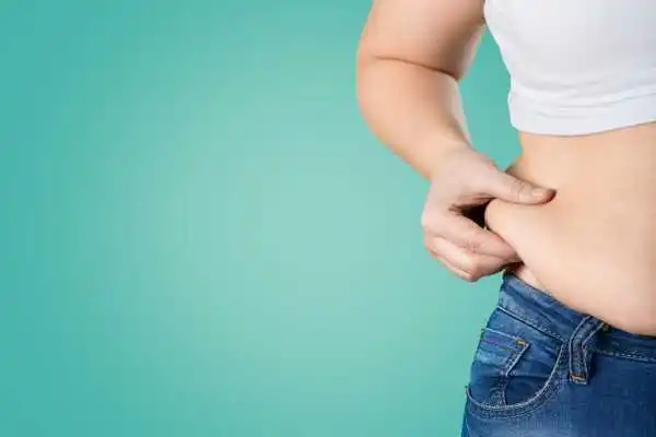 Image of woman pinching her love handles to show weight gain Moss Side